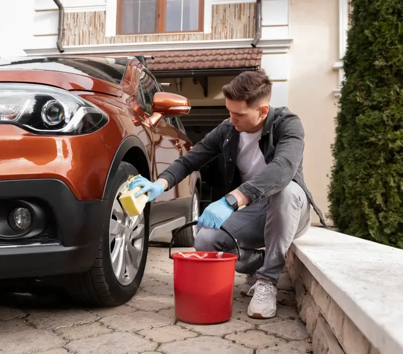 Lavage auto à domicile Réville : professionnel intervenant sur un véhicule